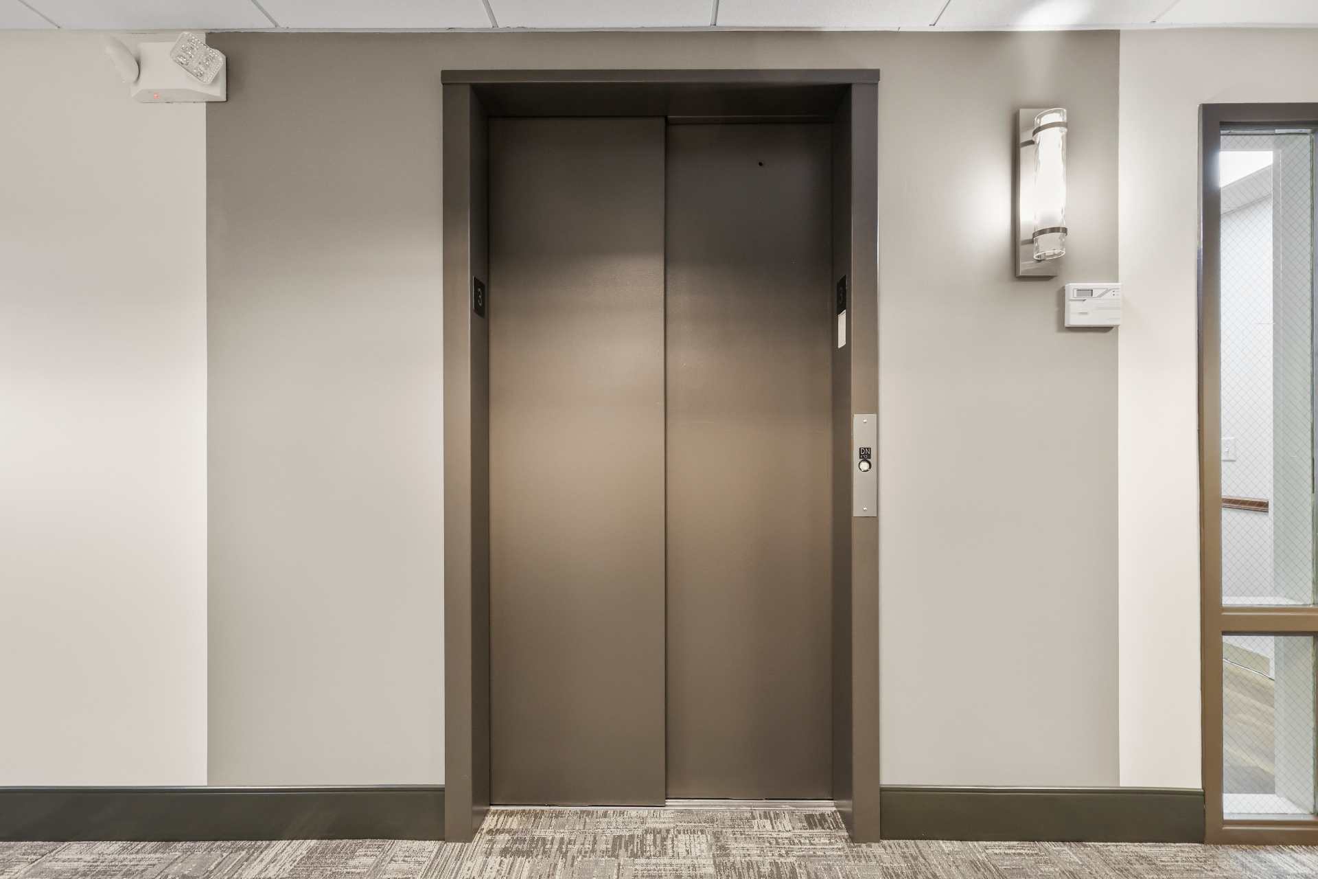 Elevator lobby with new wall finish, trim, and lighting