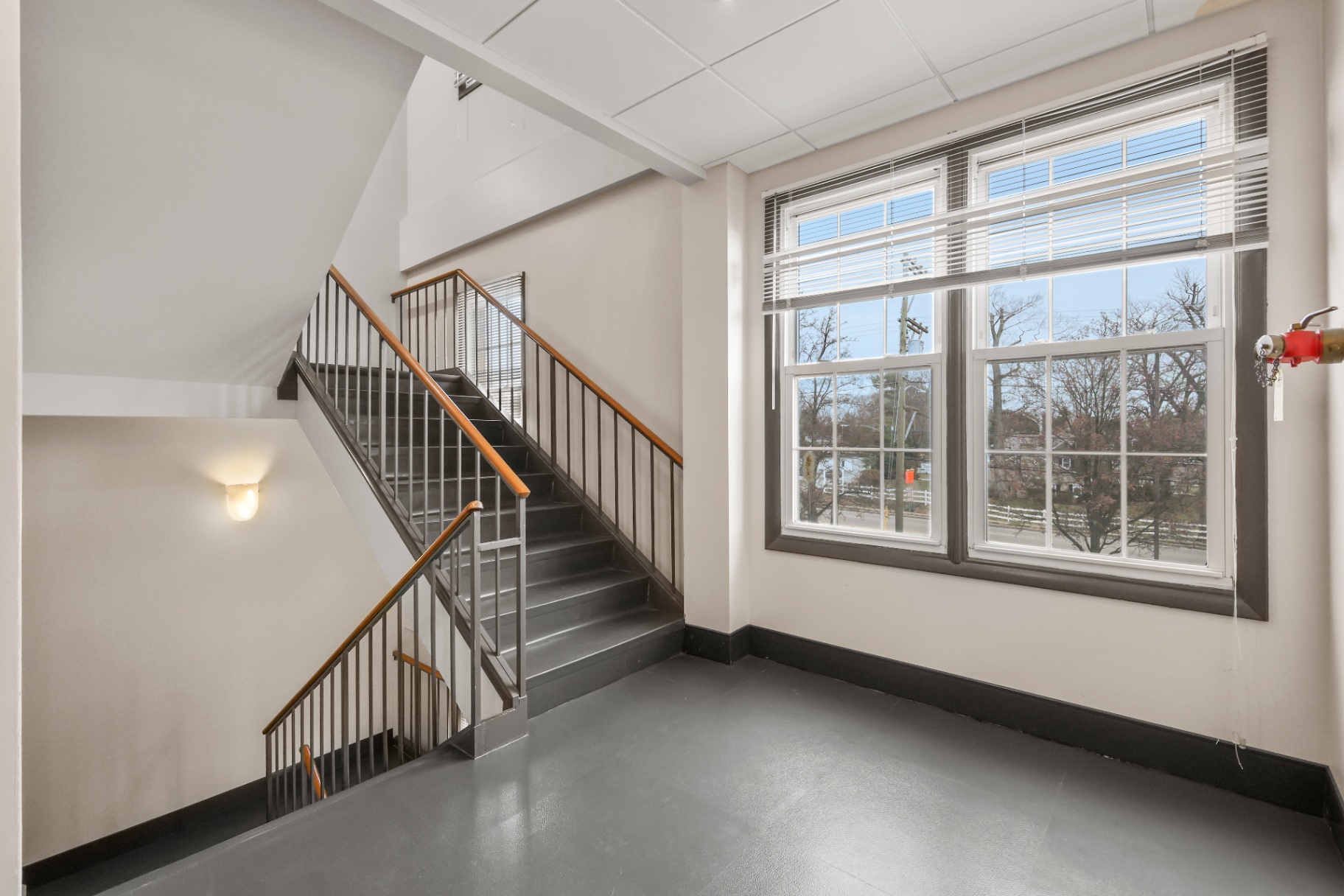 Upper stair landing with large windows and refinished railings